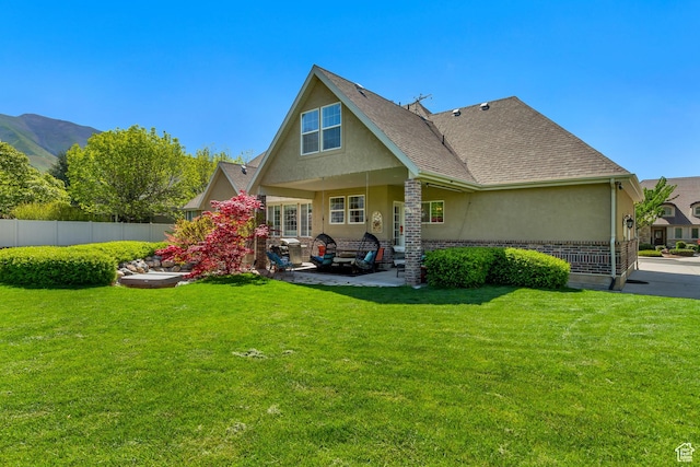 rear view of house with stucco siding, a patio area, roof with shingles, and a mountain view