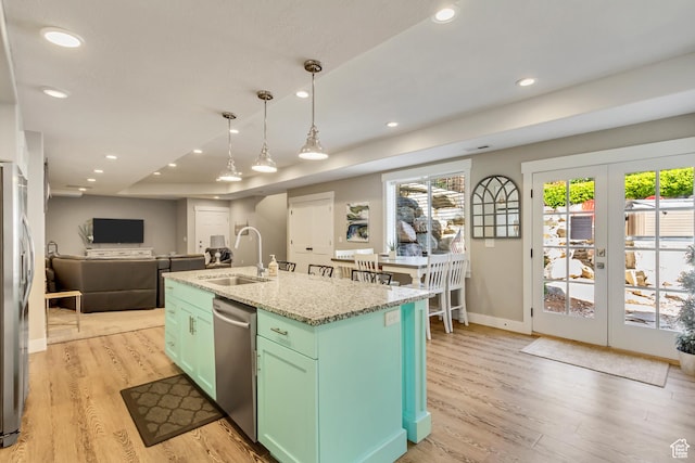 kitchen featuring a sink, stainless steel appliances, french doors, light wood-style flooring, and baseboards