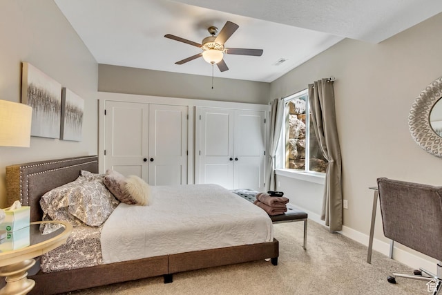 carpeted bedroom with multiple closets, baseboards, and ceiling fan