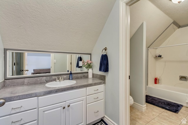 full bath featuring a textured ceiling, lofted ceiling, washtub / shower combination, vanity, and tile patterned floors