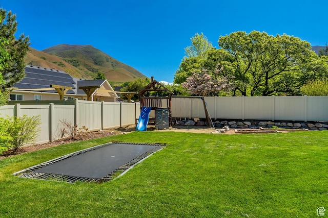 view of yard featuring a playground and a mountain view