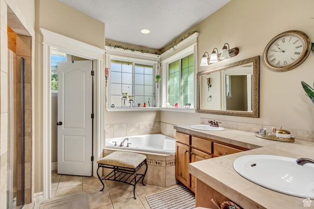 bathroom with a garden tub, tile patterned floors, double vanity, and a tile shower