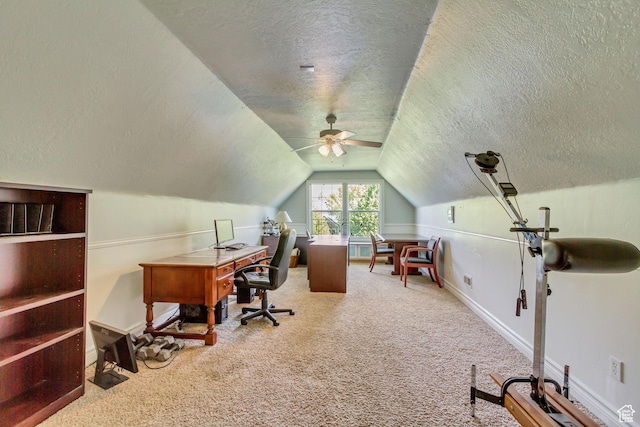 home office featuring a textured ceiling, carpet floors, lofted ceiling, ceiling fan, and baseboards