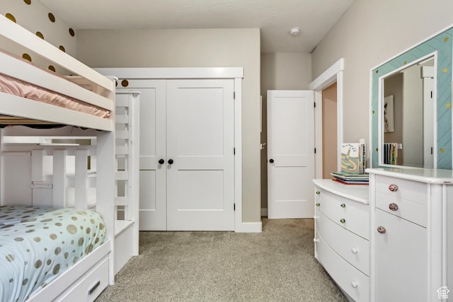 bedroom featuring light colored carpet and a closet