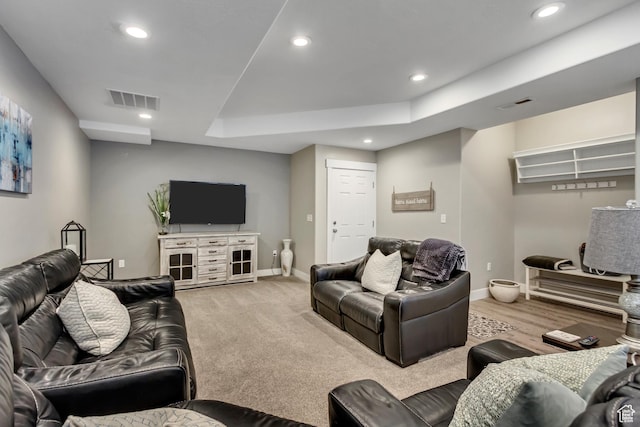living area with recessed lighting, baseboards, and a raised ceiling
