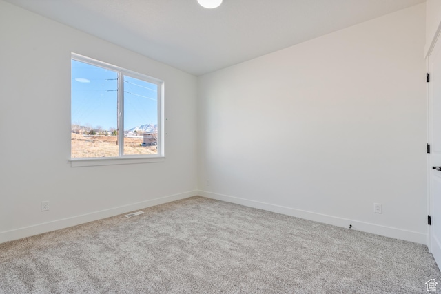 empty room featuring carpet floors and baseboards