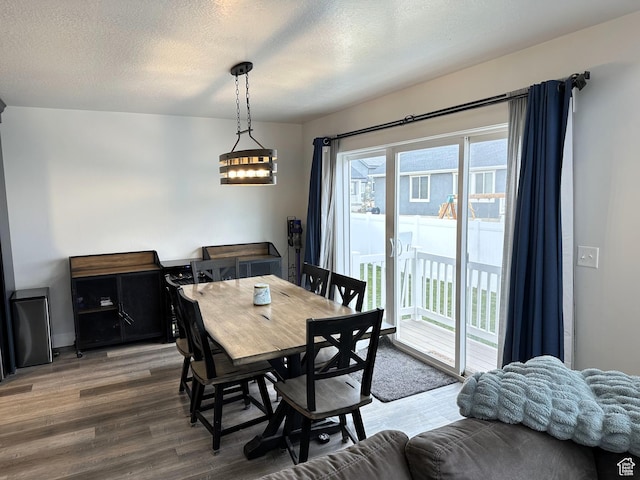dining area featuring wood finished floors and a textured ceiling