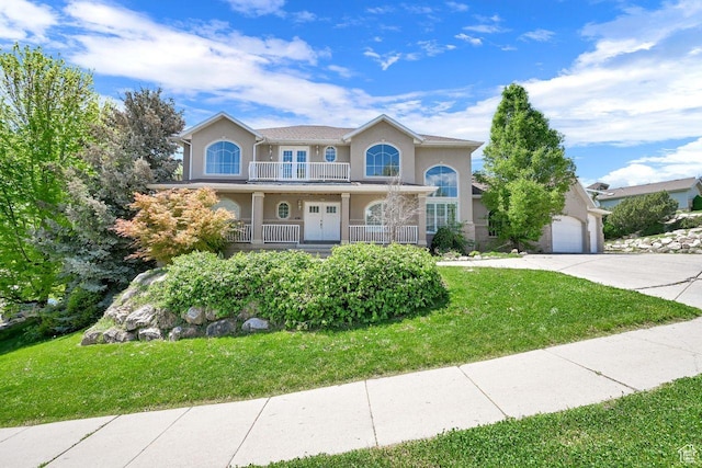 1159 E 5700 S, South Ogden, UT 84405 - view of front facade featuring french doors, concrete driveway, a front yard, stucco siding, and a balcony