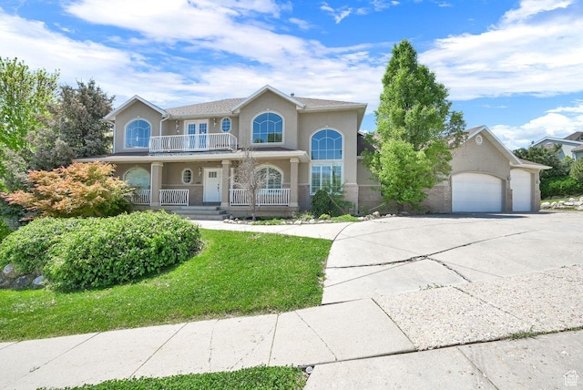 1159 E 5700 S, South Ogden, UT 84405 - view of front of home featuring a balcony, covered porch, stucco siding, concrete driveway, and a garage