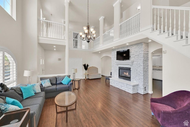 1159 E 5700 S, South Ogden, UT 84405 - living area with a towering ceiling, dark wood finished floors, a stone fireplace, arched walkways, and a chandelier