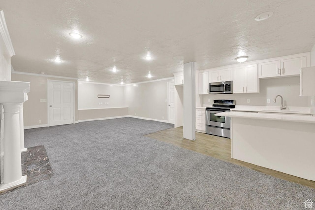 1159 E 5700 S, South Ogden, UT 84405 - kitchen featuring appliances with stainless steel finishes, ornamental molding, a sink, light carpet, and white cabinetry