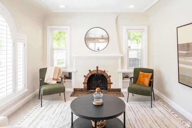 sitting room featuring healthy amount of natural light, baseboards, recessed lighting, crown molding, and a fireplace
