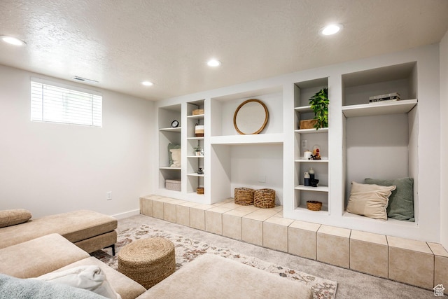 carpeted living area featuring recessed lighting, baseboards, a textured ceiling, and built in shelves