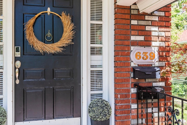 doorway to property with brick siding