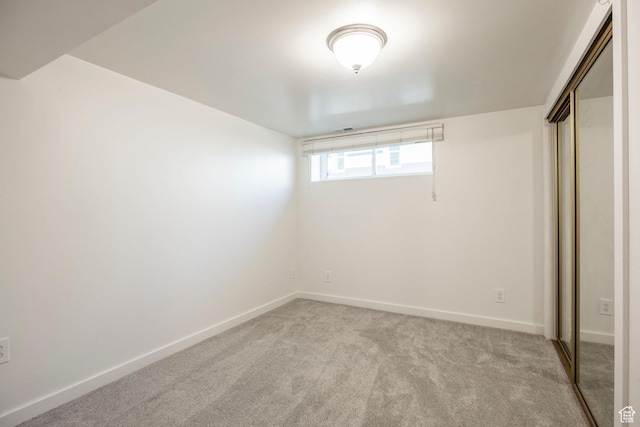 basement featuring light colored carpet and baseboards