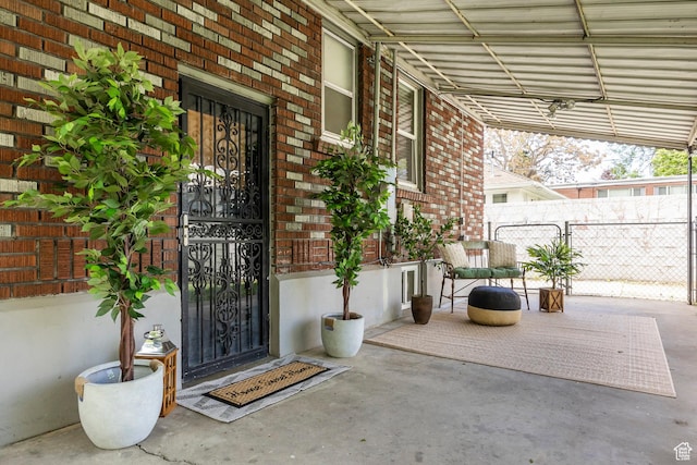 doorway to property with brick siding and fence