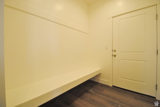 mudroom with dark wood finished floors and baseboards