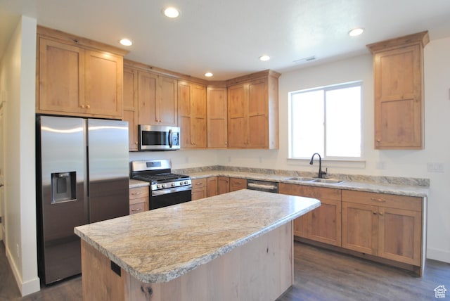 kitchen with stainless steel appliances, a sink, light countertops, recessed lighting, and a kitchen island