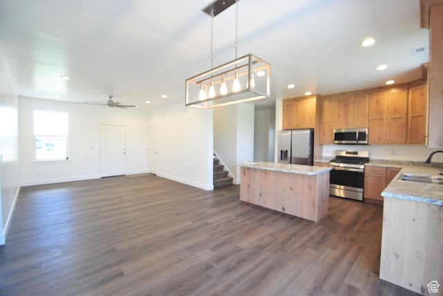 kitchen featuring stainless steel appliances, a kitchen island, baseboards, recessed lighting, and dark wood finished floors