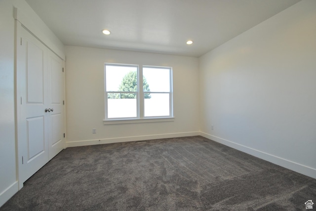 unfurnished bedroom featuring baseboards, dark colored carpet, and recessed lighting