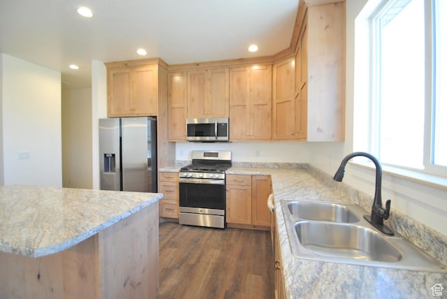 kitchen featuring stainless steel appliances, a sink, light brown cabinets, dark wood-type flooring, and recessed lighting