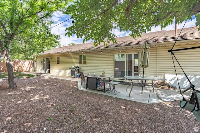 back of property featuring fence and a patio