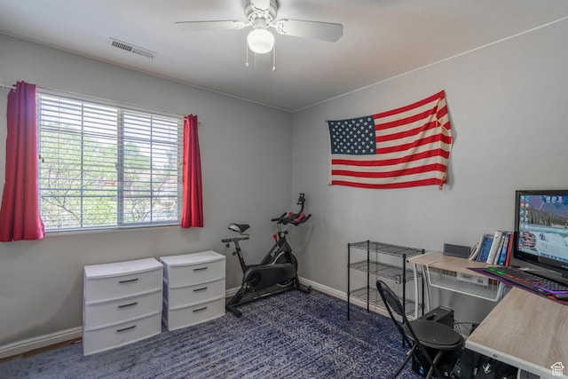 home office with dark carpet, ceiling fan, and baseboards