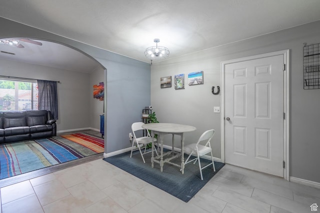 dining area featuring arched walkways, baseboards, and a chandelier