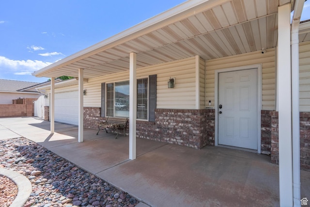 view of patio / terrace featuring concrete driveway, a garage, and covered porch