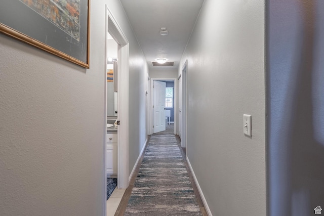 hall featuring wood finished floors and baseboards