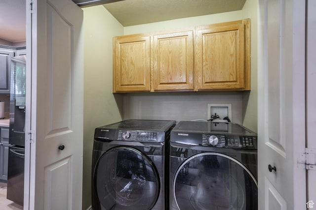 washroom featuring cabinet space and separate washer and dryer
