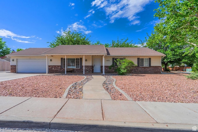 single story home featuring brick siding, an attached garage, concrete driveway, and a tiled roof
