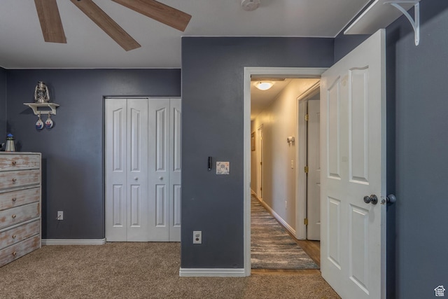 bedroom featuring a closet, baseboards, carpet flooring, and ceiling fan