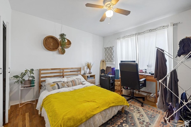 bedroom with wood finished floors, a desk, and ceiling fan