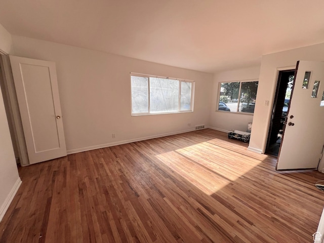 unfurnished living room with wood finished floors and baseboards