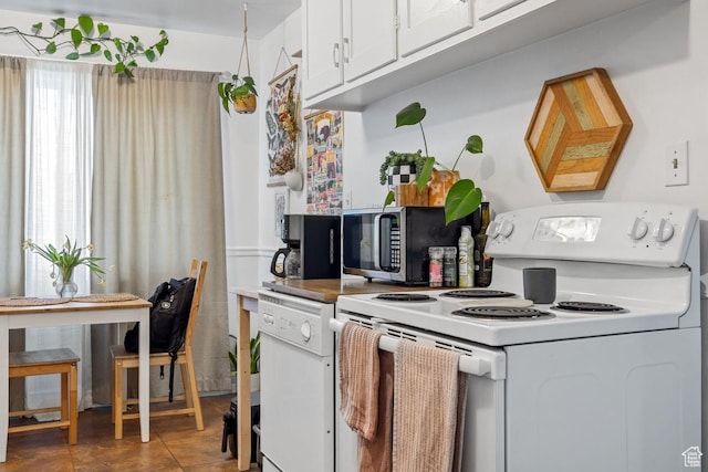 kitchen with white electric stove, stainless steel microwave, and white cabinetry