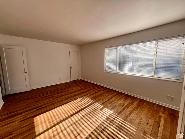 empty room with wood finished floors and baseboards