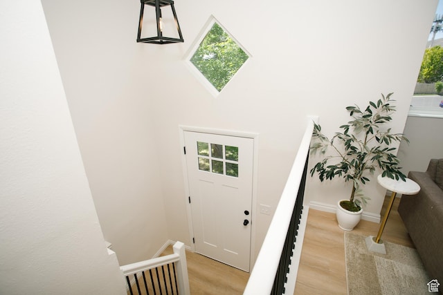 entryway featuring healthy amount of natural light, light wood-type flooring, and baseboards