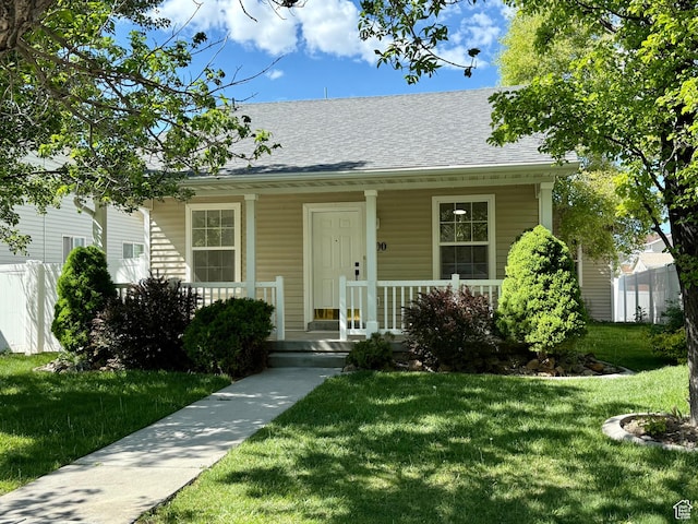 bungalow-style house with covered porch, a front lawn, and roof with shingles