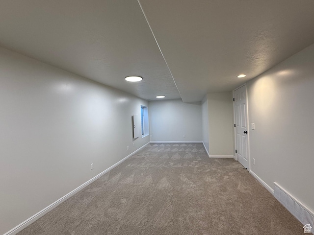 finished below grade area with carpet flooring, recessed lighting, and baseboards