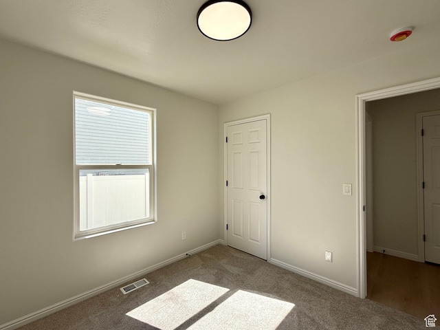 unfurnished bedroom with carpet floors and baseboards