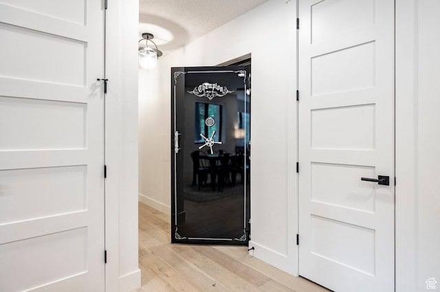 9335 N Canopy Ln E, Sundance, UT 84604 - hallway with light wood-type flooring, baseboards, and a textured ceiling