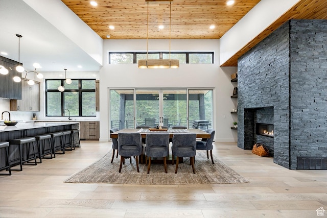 9335 N Canopy Ln E, Sundance, UT 84604 - dining space with light wood-style flooring, wooden ceiling, recessed lighting, a high ceiling, and a fireplace