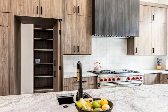 9335 N Canopy Ln E, Sundance, UT 84604 - kitchen featuring range with two ovens, wall chimney range hood, backsplash, and light stone counters
