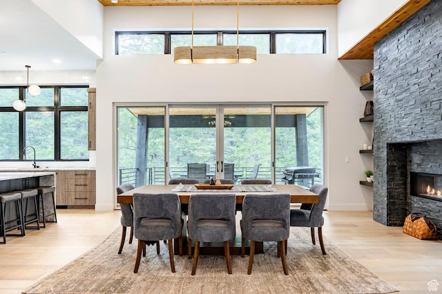 9335 N Canopy Ln E, Sundance, UT 84604 - dining area with a high ceiling, light wood-style floors, plenty of natural light, and a stone fireplace
