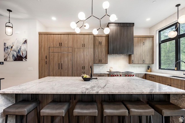 9335 N Canopy Ln E, Sundance, UT 84604 - kitchen with a breakfast bar area, a sink, decorative backsplash, hanging light fixtures, and a spacious island