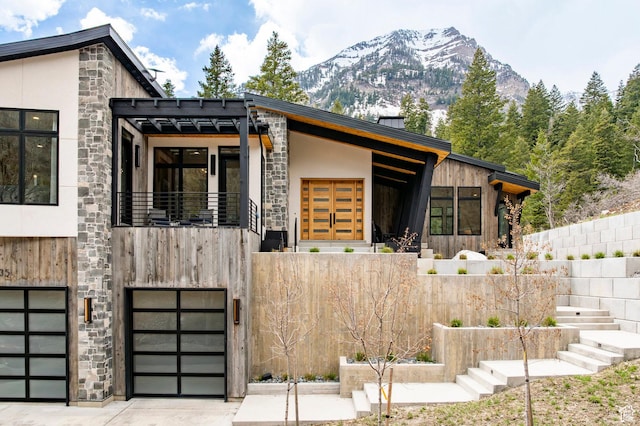 9335 N Canopy Ln E, Sundance, UT 84604 - modern home with stone siding, a mountain view, a garage, stucco siding, and driveway