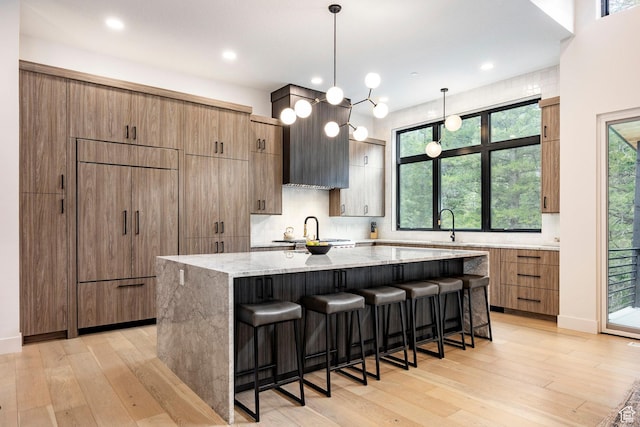 9335 N Canopy Ln E, Sundance, UT 84604 - kitchen featuring a large island, light wood-style flooring, light stone counters, a breakfast bar area, and recessed lighting