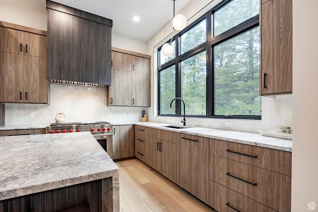 9335 N Canopy Ln E, Sundance, UT 84604 - kitchen featuring a sink, stainless steel range, light wood-style flooring, custom range hood, and tasteful backsplash