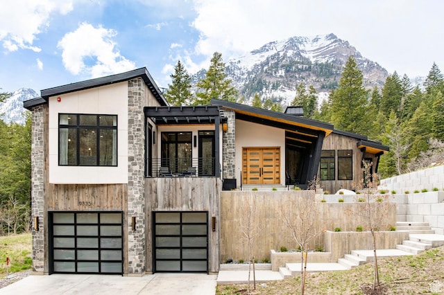9335 N Canopy Ln E, Sundance, UT 84604 - contemporary house with a garage, driveway, stone siding, and a mountain view